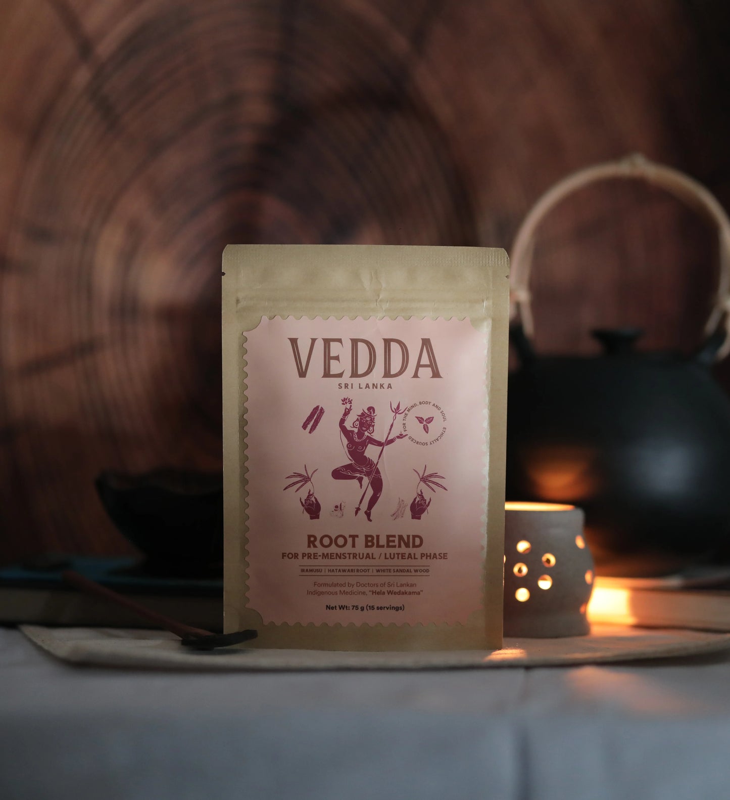 Vedda root blend package on a wooden surface with a candle in the background