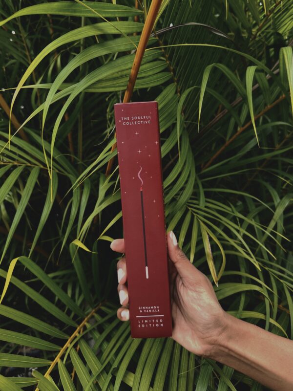 Red product box held in front of green foliage
