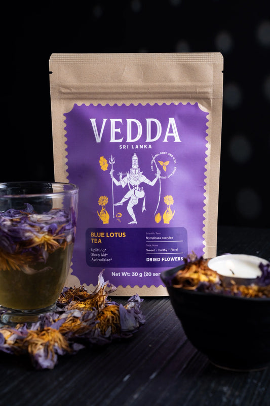 Vedda Sri Lanka Blue Lotus Tea package with a cup of tea and dried flowers on a dark background