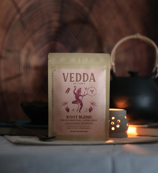 Vedda root blend package on a wooden surface with a candle in the background
