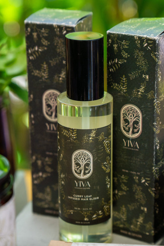 YIVA curry leaf hair elixir bottle with black and gold design on a blurred green background