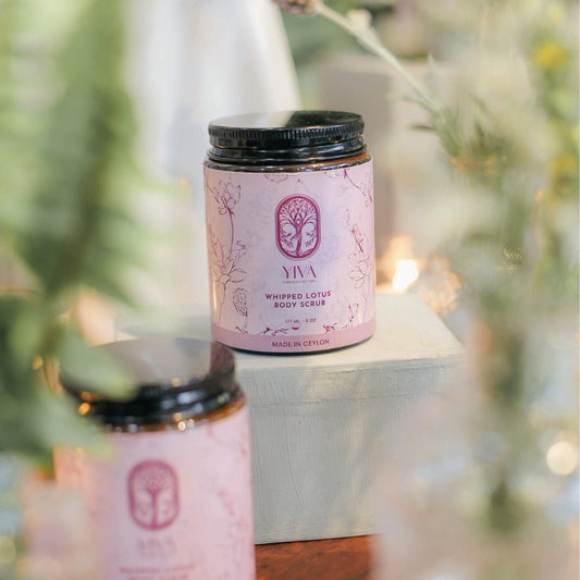 YIVA whipped lotus body scrub jar with decorative elements on a blurred background
